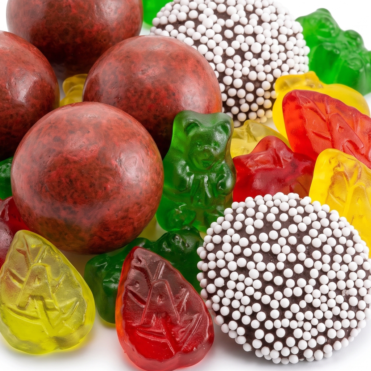 Close-up of pumpkin spice malt balls, dark chocolate nonpareils, green gummi bears and red and yellow leaf-shaped apple gummies from The Fall Edit.